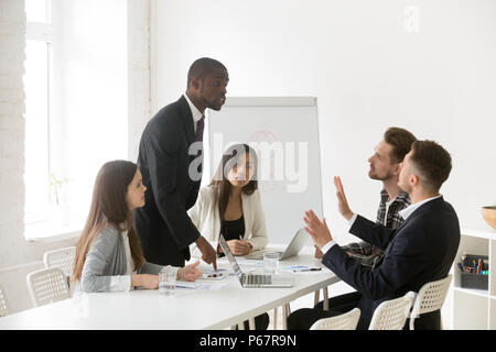 Angry African American shouting at Caucasian colleague blaming Stock Photo