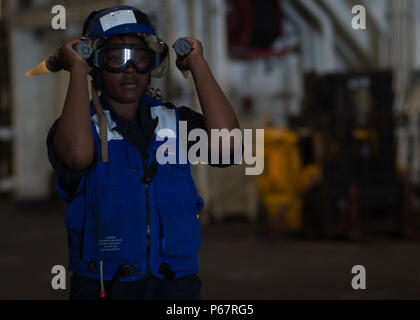 {filename base} GULF OF ADEN (May 12, 2016) Seaman Jalisa Franklin signals to a landing craft, air cushion assigned to Assault Craft Unit (ACU) 5 in the well deck of the amphibious transport dock ship USS New Orleans (LPD 18). USS New Orleans is part of the Boxer Amphibious Ready Group and, with the embarked 13th Marine Expeditionary Unit, is deployed in support of maritime security operations and theater security cooperation efforts in the 5th Fleet area of operations. (U.S. Navy Photo by Mass Communication Specialist 3rd Class Chelsea D. Daily/ Released) Stock Photo