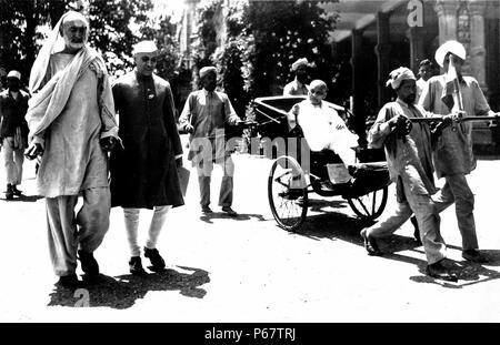 Khan Abdul Ghaffar Khan and Jawaharlal Nehru walk to a Congress meeting, while Sardar Patel is pulled alongside in a rickshaw. Stock Photo