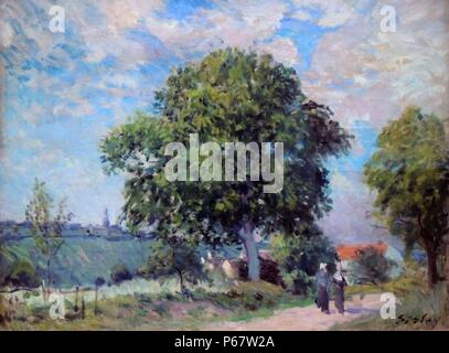 Alfred Sisley (1839-1899) The Entrance to the Village.  A country road between grassy banks, lined with trees leads the viewer's gaze diagonally into the picture towards a white building with a red roof on the right. A majestic tree rises above the scene in the centre of the picture.  Beyond, the land drops and rises again in the background where a church and other buildings are silhouetted against the lightly clouded sky. Stock Photo