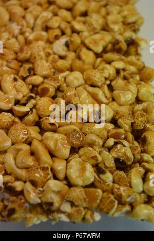 On a white paper background is located and placed from a delicious and sweet grilling of air corn kernels, popcorn with caramel Stock Photo