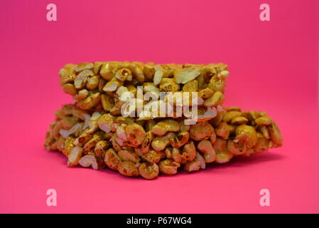 On a bright colorful pink paper background is located and placed from a delicious and sweet grilling of air corn kernels, popcorn with caramel Stock Photo