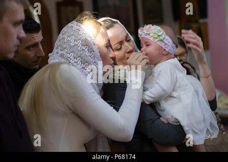 Belarus, Gomel, 25 March. 2018. The Prudhkovsky Church.Mother and godmother on a baptismal rite.Parents with a child in the church at the ceremony of  Stock Photo