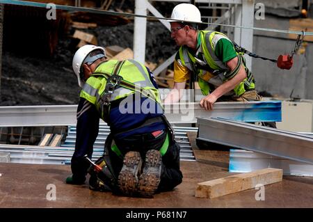 Construction workers laying plywood flooring, London, UK Stock Photo