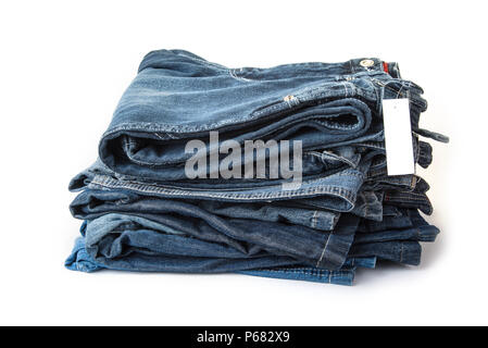 Pile of blue jeans with blank price tag on the white Stock Photo