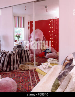 Mirrored doors on fitted wardrobe in teenage bedroom with arge pink velour elephant and tiger-striped velour beanbag         FOR EDITORIAL USE ONLY Stock Photo