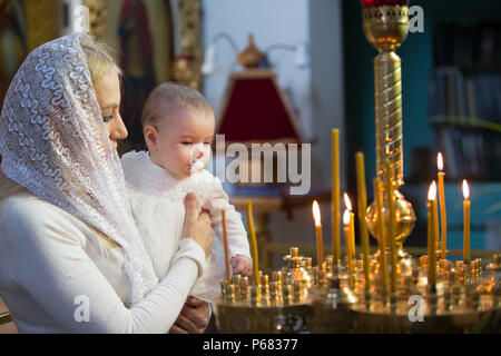 Belarus, Gomel, 25 March. 2018. The Prudhkovsky Church.The mother holds the child on her hands during the rite of baptism.Accept religion Stock Photo