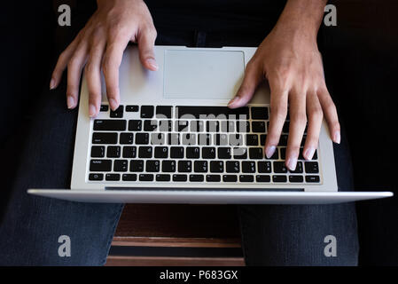 top view of human hands typing on laptop computer Stock Photo