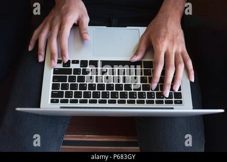 top view of human hands typing on laptop computer Stock Photo