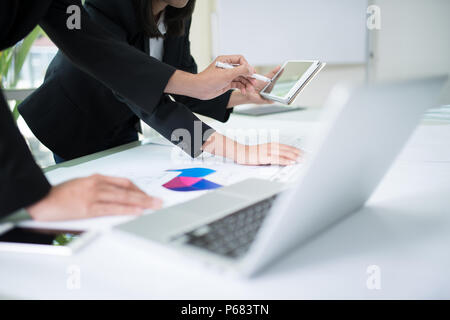 Team of business discussion of project, closeup hand of business man holding pen and pointing to tablet Stock Photo