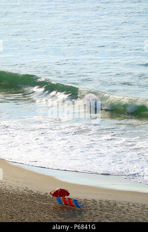 Aerial view of vivid color beach chairs and Parasol on the sandy beach with big waves, Copacabana Beach, Brazil Stock Photo