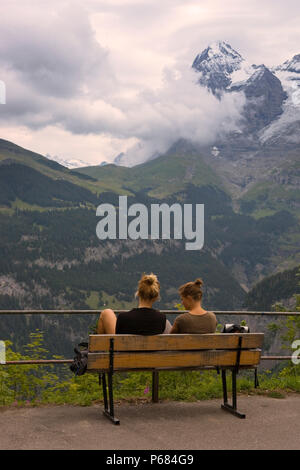 Two girls admire the view from Mürren of the Lauterbrunnen valley and the Mönch beyond, Bernese Oberland, Switzerland Stock Photo