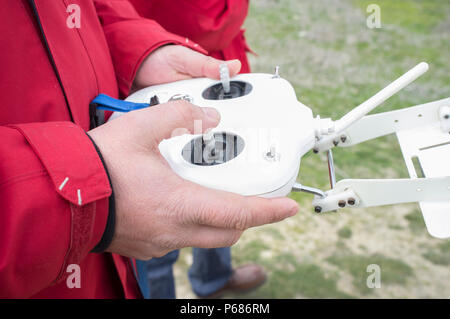 Pilot maneuver dron on remote controller. Moving right control stick for throttle Stock Photo