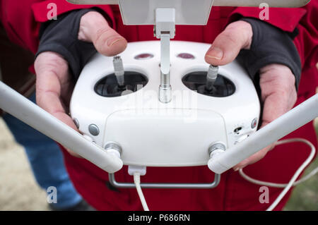 Pilot maneuver dron on remote controller. Moving left control stick for pitch Stock Photo