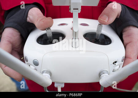 Pilot maneuver dron on remote controller. Moving right control stick for throttle Stock Photo