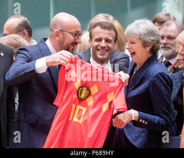 Brussels, Belgium. 28th June, 2018. Belgian Prime Minister Charles Michel (L) offers a Belgian National Soccer team jersey to British Prime Minister Theresa May (R) as France's President Emmanuel Macron (C) looks on at the first day of a two-day EU Summit in Brussels, Belgium, June 28, 2018. Credit: Thierry Monass/Xinhua/Alamy Live News Stock Photo