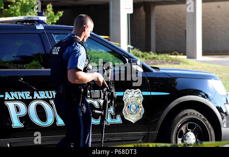 Annapolis, USA. 28th June, 2018. A police officer patrols the scene of a mass shooting in Annapolis, the capital city of eastern U.S. state Maryland, on June 28, 2018. Five people were killed on Thursday afternoon with several 'gravely injured' in a mass shooting at local daily newspaper Capital Gazette in Annapolis, police said. Credit: Yang Chenglin/Xinhua/Alamy Live News Stock Photo