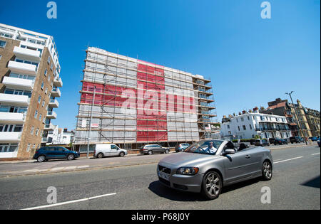 Hove Brighton, UK. 29th June, 2018. A giant England St Georges Cross flag has been put up by scaffolders on a block of flats in St Catherines Terrace along Hove seafront near Brighton . The 120ft by 60ft flag has been put up by Seasons Scaffolding in support of England in the 2018 World Cup being held in Russia with their next round game coming up against Colombia early next week Credit: Simon Dack/Alamy Live News Stock Photo