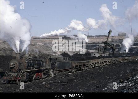 The vast opencast coal mine at Manzhouli in Inner Mongolia on the Russian border in north east China. The coal and spoil is bought out by steam trains Stock Photo