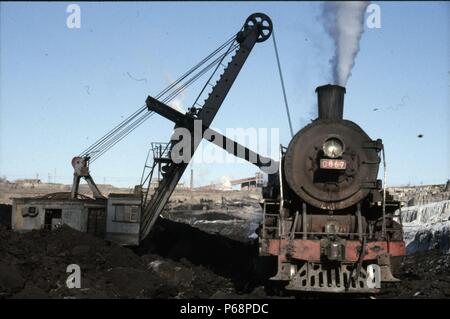 The vast opencast coal mine at Manzhouli in Inner Mongolia on the Russian border in north east China. The coal and spoil is bought out by steam trains Stock Photo