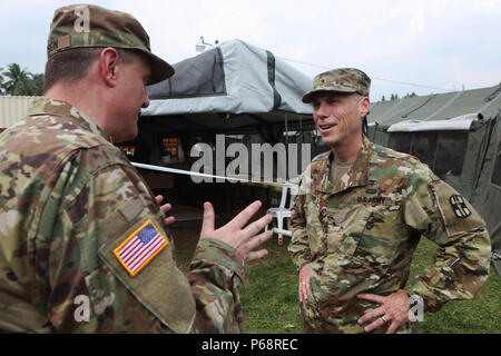 U.S. Army Brigadier Gen. James Mason, 807th Medical Command, Salt Lake City, Ut., is addressed by Col. Kenneth Lawson, Army Support Activities Command Chaplain, Fort Dix, Nj., on treatment areas a the medical readiness exercise in San Pablo, Guatemala, May 17, 2016. Task Force Red Wolf and Army South conducts Humanitarian Civil Assistance Training to include tactical level construction projects and Medical Readiness Training Exercises providing medical access and building schools in Guatemala with the Guatemalan Government and non-government agencies from 05MAR16 to 18JUN16 in order to improve Stock Photo
