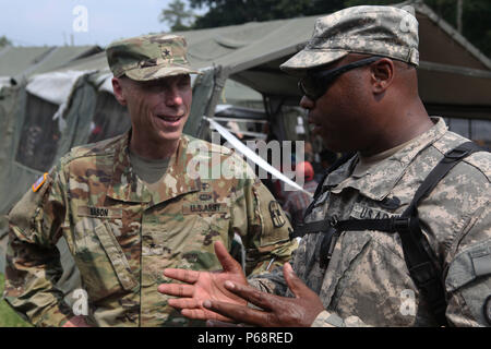 U.S. Army Maj. James Nelson (right), 71st Theatre Information Operations Group, briefs Brigadier Gen. James Mason on the operations of a medical readiness site in San Pablo, Guatemala, May 17, 2016. Task Force Red Wolf and Army South conducts Humanitarian Civil Assistance Training to include tactical level construction projects and Medical Readiness Training Exercises providing medical access and building schools in Guatemala with the Guatemalan Government and non-government agencies from 05MAR16 to 18JUN16 in order to improve the mission readiness of US Forces and to provide a lasting benefit Stock Photo