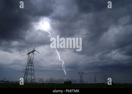 Lightning storm on electric tower. Dramatic sky and thunderstorm over energy station. Stock Photo