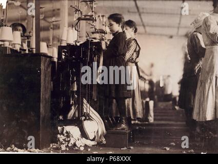 Photograph of a young girl employed as a knitter in the Loudon Hosiery Mills, Loudon, Tennessee. She stands on a box to reach the machine. Dated 1910 Stock Photo