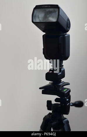 External photographic flashlight gun is mounted on the remote wireless control radio trigger set, which stands on a tripod. lighting equipment for stu Stock Photo