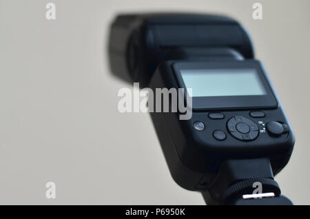 External photographic flash is mounted on the synchronizer, which stands on a tripod. lighting equipment objects. Set of professional studio photograp Stock Photo