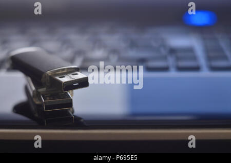 USB flash cards lying on black laptop case in front of his keyboard. Virtual memory storage with USB output Stock Photo