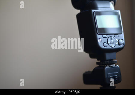 External photographic flash is mounted on the synchronizer, which stands on a tripod. lighting equipment objects. Set of professional studio photograp Stock Photo