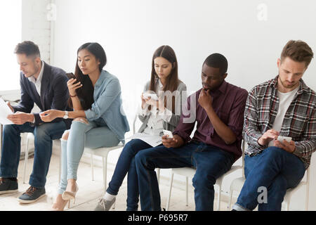 Diverse work candidates holding devices preparing for job interv Stock Photo