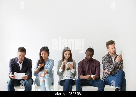 Multiethnic applicants preparing for job interview waiting in qu Stock Photo