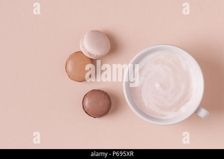 Cup of coffee with macaroons on pastel background, flat lay. Stock Photo