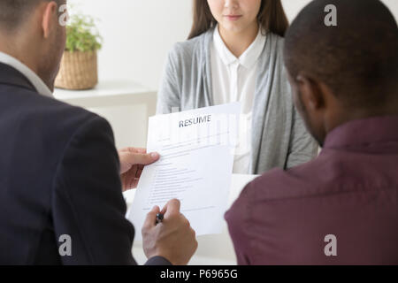 HR managers reading female employee resume in office Stock Photo
