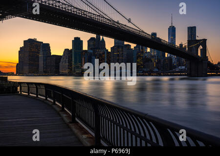 Lower Manhattan skyscrapers and the Brooklyn Bridge at sunset from Empire Fulton Ferry Park (Brooklyn). Manhattan, New York City Stock Photo