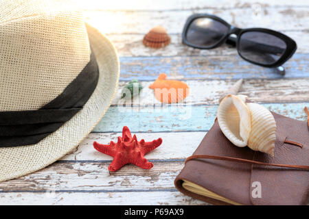 Summer concept with hat, sunglasses, diary, and seashells Stock Photo