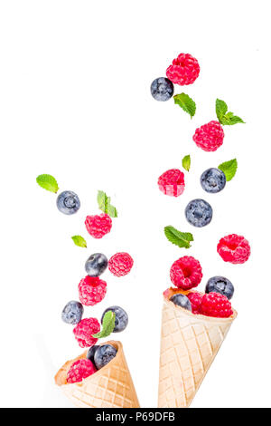 Creative layout with raspberry and blueberry with waffle ice cream cones, simple pattern above copy space Stock Photo