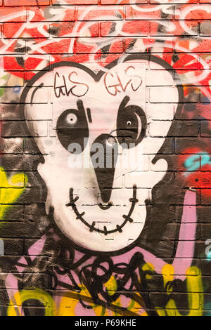 London Waterloo Leake Street graffiti detail cartoon face black white yellow long nose mouth sewed up Stock Photo