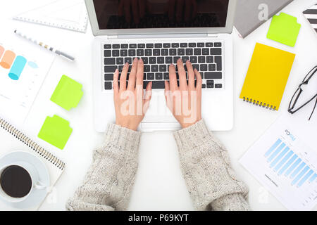 Young woman sitting at the table top view business concept typing Stock Photo