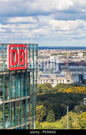 DB Logo on the top of Bahn Tower, German Railway (Deutsche Bahn) HQ. German parliament building (Bundestag) on the background Stock Photo