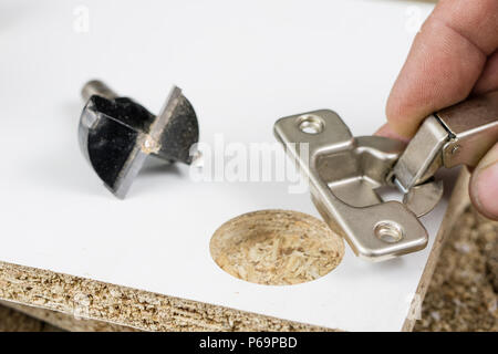 Milling cutter for fixing hinges in chipboard. Joinery accessories for furniture construction. Place - an old carpentry workshop. Stock Photo