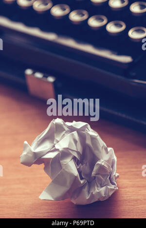 Writer's block concept with typewriter and crumpled paper on work desk Stock Photo