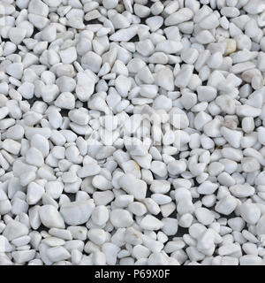A lot of round and oval stones of white color lie on the ground in the garden . Stock Photo