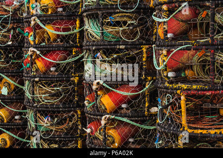 close up shot of crabbing pots stacked uniformly in a row near a building in newport oregon on the coast in a bay. Stock Photo