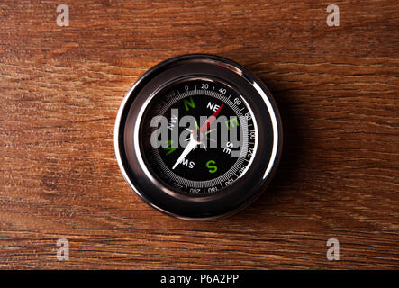 tourist compass lying on a wooden table closeup Stock Photo