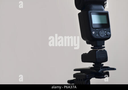 External photographic speedlight gun is mounted on the multichannel sync trigger set on a tripod. lighting equipment for studio photography. Set of pr Stock Photo