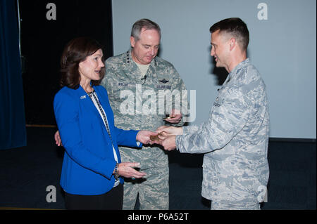 Maxwell AFB, Ala. - General Mark A. Welsh, III, twentieth Chief of Staff of the US Air Force and his spouse are presented medallions honoring their outstanding contributions to the educational success of the Ira C. Eaker Center for Professional Development and its Wing Commander and Wing Commander Spouses courses by ECPD Commander Colonel Kenneth Tatum in the Kaysing Auditorium, April 14, 2016.  (US Air Force photo by Melanie Rodgers Cox/Released) Stock Photo