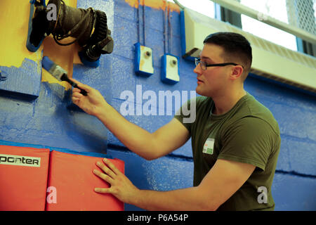 Cpl. Austin Richards, a flight equipment technician with Marine Medium Tiltrotor Squadron 261, paints the gymnasium of the Graham Windham’s Manhattanville Cornerstone Community Center in Manhattan, New York, May 27, 2016. The Marines are visiting the city to interact with the public, demonstrate capabilities and teach the people of New York about America's sea services. Stock Photo